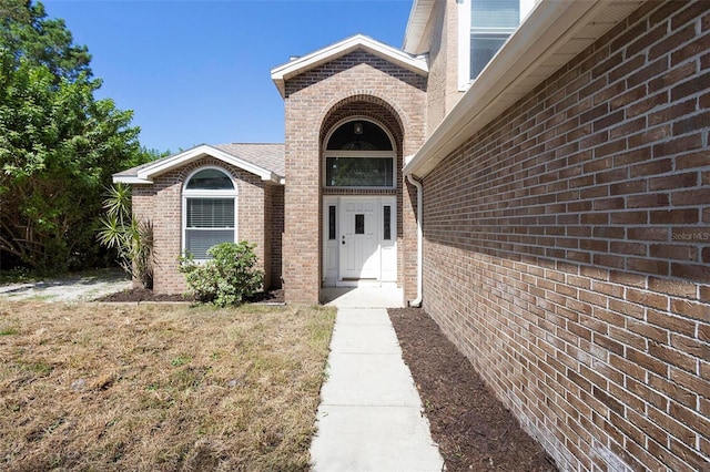 entrance to property with a lawn