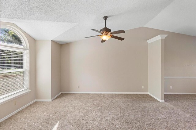 carpeted spare room featuring ceiling fan, a wealth of natural light, a textured ceiling, and vaulted ceiling