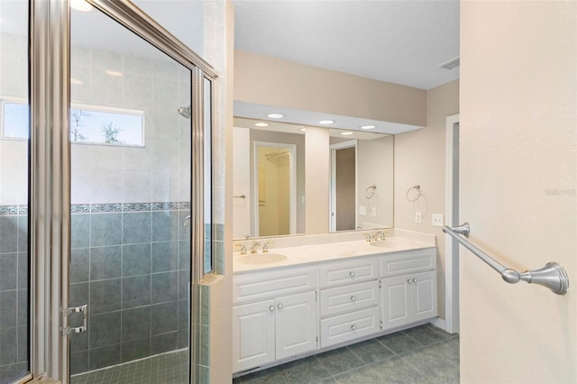 bathroom featuring tile patterned flooring, an enclosed shower, and vanity