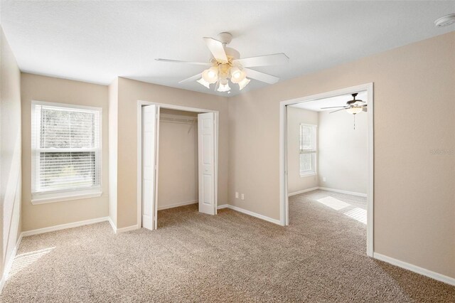 unfurnished bedroom featuring ceiling fan and light carpet