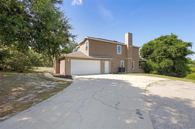 view of property exterior with cooling unit and a garage