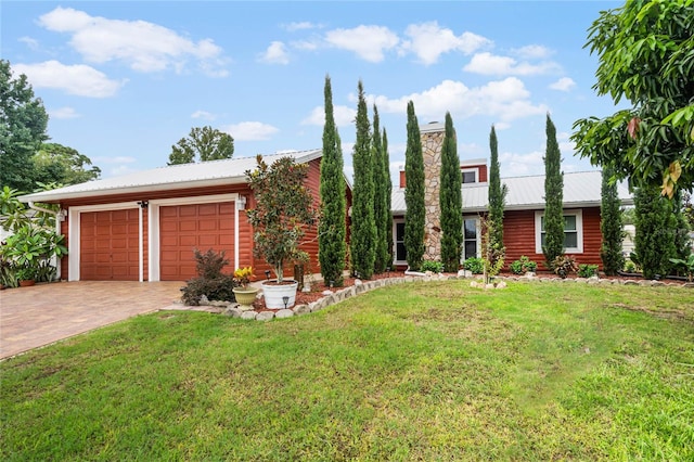 view of front of property with a garage and a front lawn