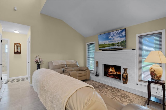 living room with vaulted ceiling, light tile patterned flooring, and a fireplace