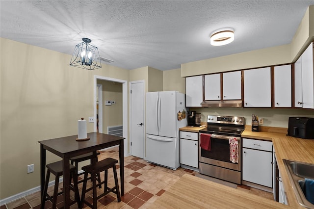 kitchen with stainless steel range with electric stovetop, a notable chandelier, white fridge, white cabinetry, and hanging light fixtures