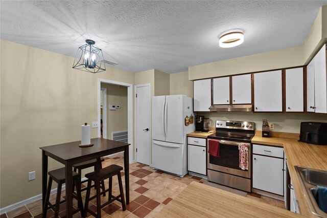 980 Bluebird Ter, Deltona, FL 32725 - kitchen featuring white cabinets, under cabinet range hood, freestanding refrigerator, butcher block countertops, and electric range