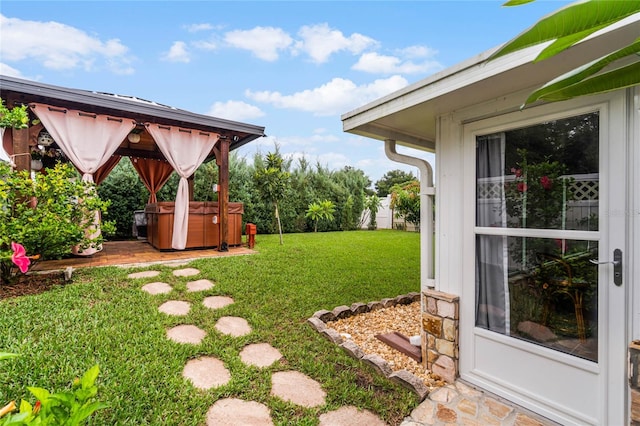 view of yard with a hot tub and a gazebo