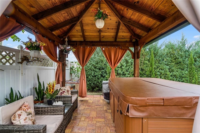 view of patio with a hot tub, an outdoor hangout area, and a gazebo