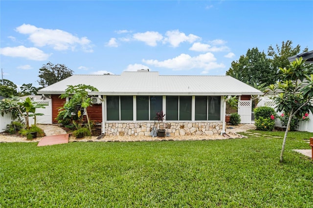 980 Bluebird Ter, Deltona, FL 32725 - back of house with a lawn, a sunroom, stone siding, and metal roof