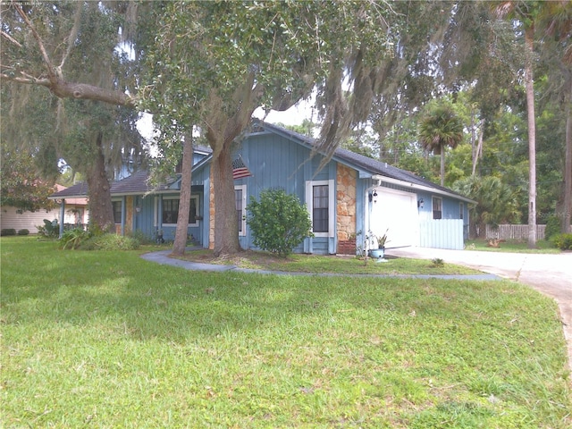 ranch-style house with a garage, stone siding, concrete driveway, and a front yard