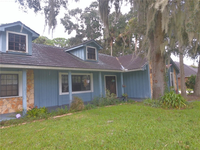 view of front of home with stone siding, board and batten siding, and a front yard