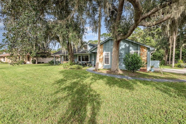 view of front facade featuring a front yard and stone siding