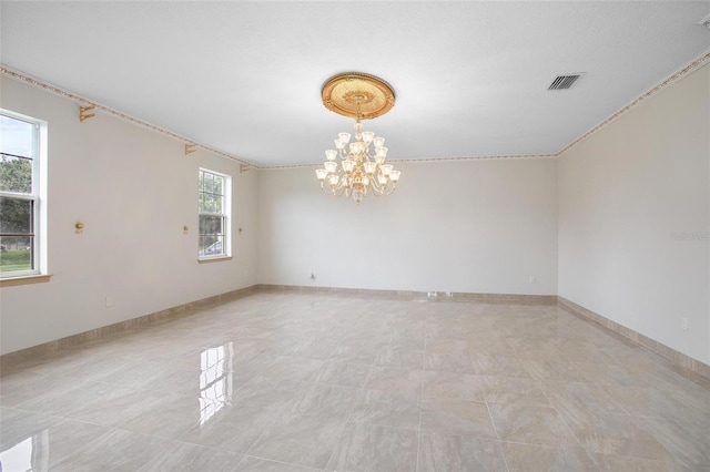 spare room featuring a notable chandelier and crown molding