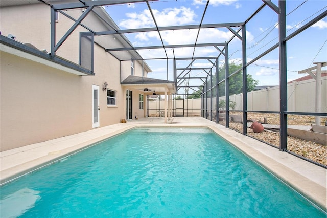 view of swimming pool featuring glass enclosure and a patio area