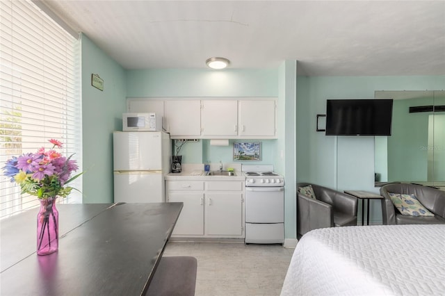 bedroom featuring light carpet, white fridge, and sink