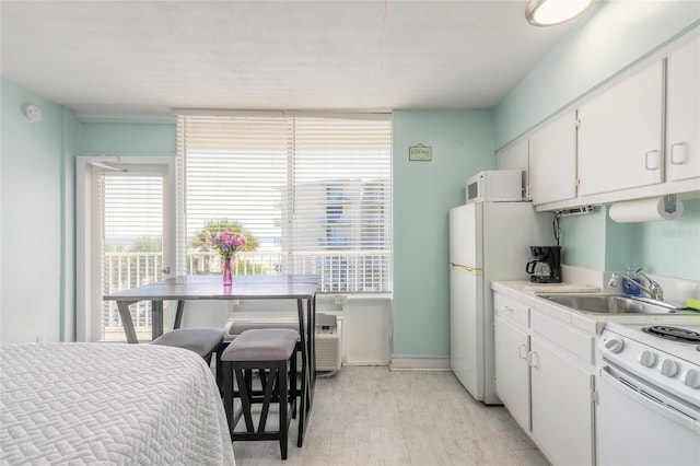 kitchen with white cabinets, light wood-type flooring, sink, and white appliances