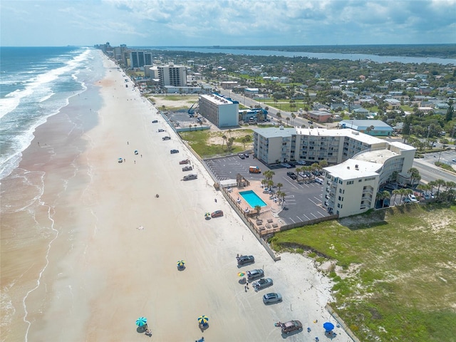 drone / aerial view featuring a water view and a view of the beach