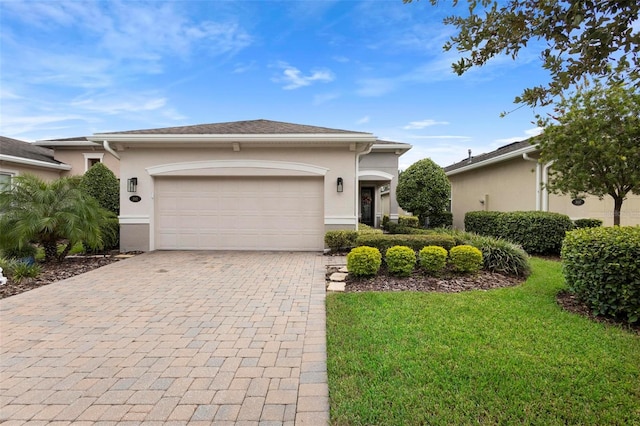 single story home with a garage and a front lawn