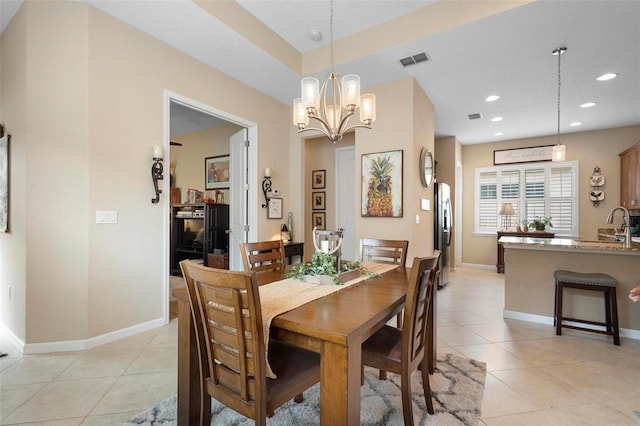 dining area with an inviting chandelier, light tile patterned floors, and sink