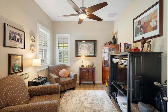 sitting room featuring light wood-type flooring and ceiling fan