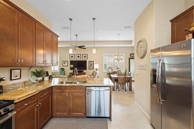 kitchen with pendant lighting, sink, kitchen peninsula, stainless steel appliances, and ceiling fan with notable chandelier