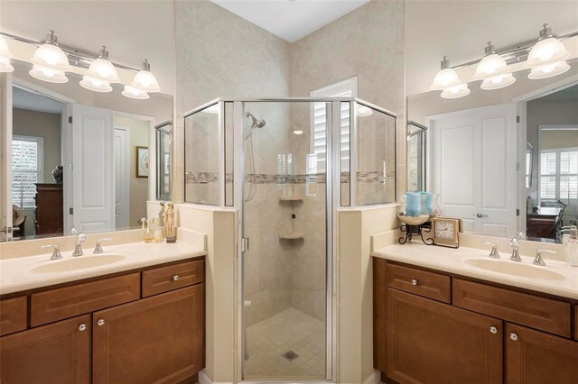 bathroom with a shower with door and vanity