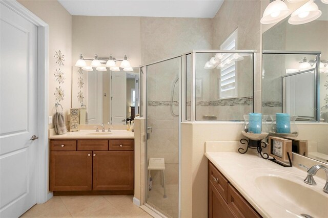 bathroom featuring tile patterned floors, a shower with door, and vanity