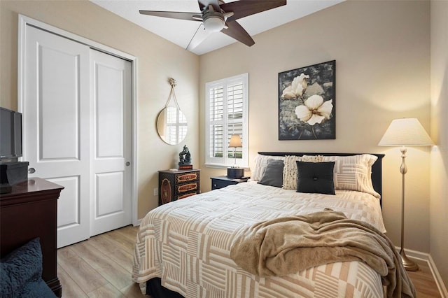 bedroom featuring ceiling fan, light hardwood / wood-style flooring, and a closet