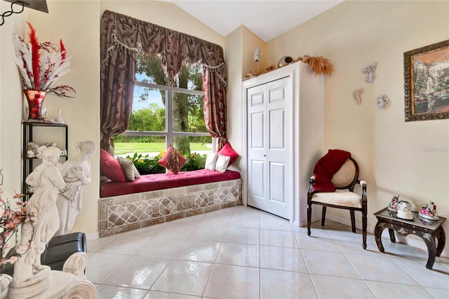 living area with vaulted ceiling and light tile patterned floors