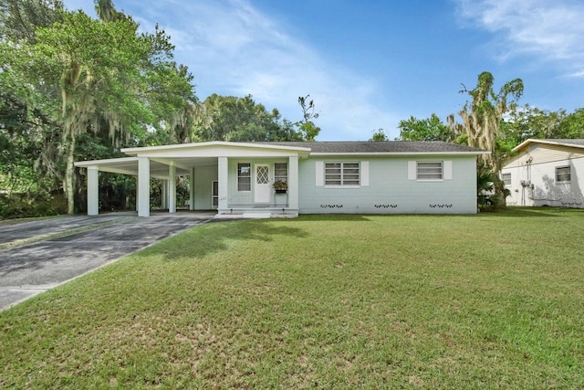 ranch-style house featuring a front lawn and a carport