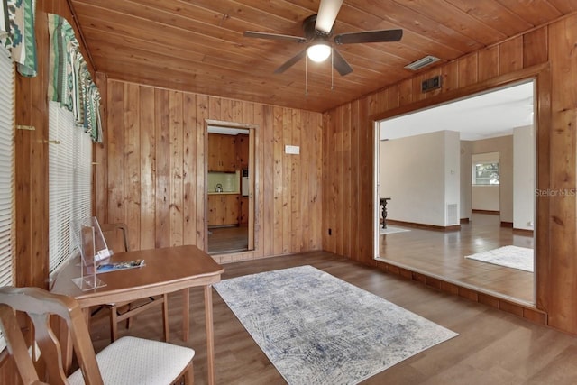 office space with ceiling fan, wooden walls, and dark wood-type flooring