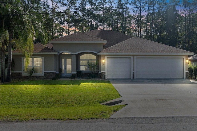 view of front of property with a yard and a garage