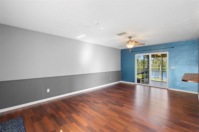 empty room with dark hardwood / wood-style flooring and ceiling fan