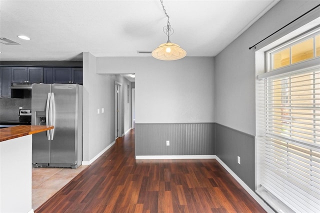 kitchen with butcher block counters, electric range, stainless steel fridge with ice dispenser, dark hardwood / wood-style flooring, and pendant lighting