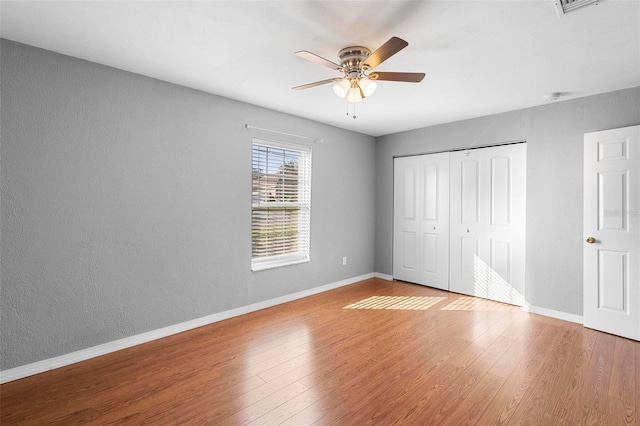 unfurnished bedroom with a closet, light hardwood / wood-style flooring, and ceiling fan