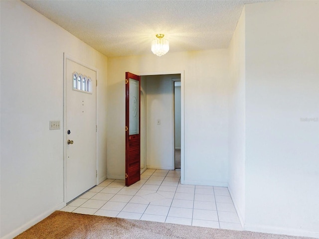 foyer with light tile patterned flooring and a textured ceiling