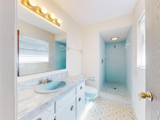 bathroom featuring tiled shower, vanity, and toilet