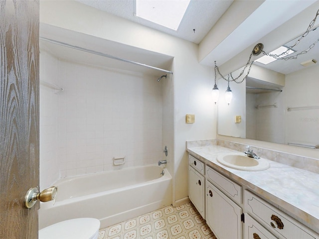 full bathroom featuring vanity, tiled shower / bath, a skylight, and toilet