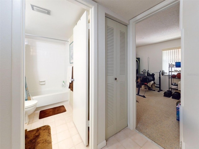 bathroom with a textured ceiling, shower / bath combo with shower curtain, and toilet