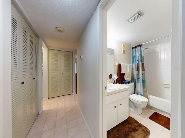 full bathroom featuring vanity, a textured ceiling, shower / bath combo, tile patterned flooring, and toilet