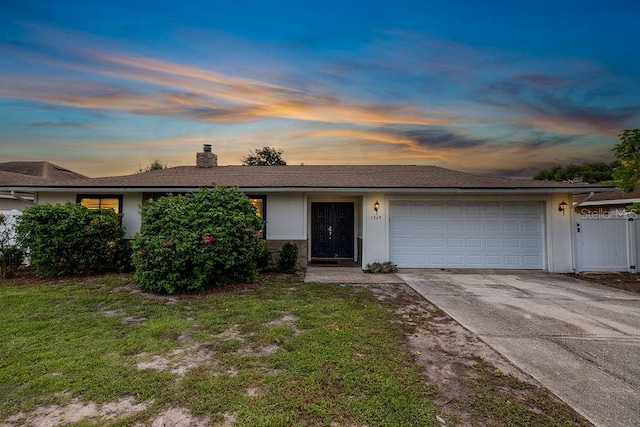 ranch-style house with a yard and a garage