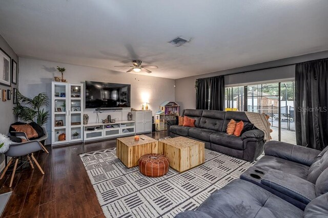 living room featuring ceiling fan and dark wood-type flooring