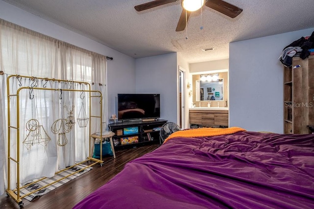 bedroom with ensuite bath, a textured ceiling, ceiling fan, and dark hardwood / wood-style flooring