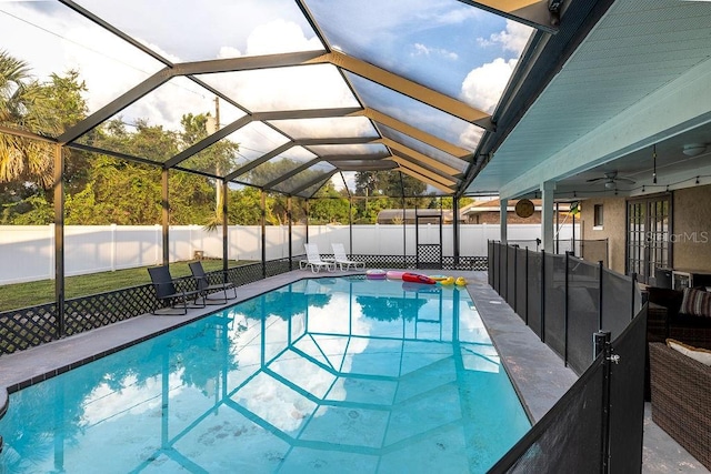 view of pool with glass enclosure, ceiling fan, and a patio area