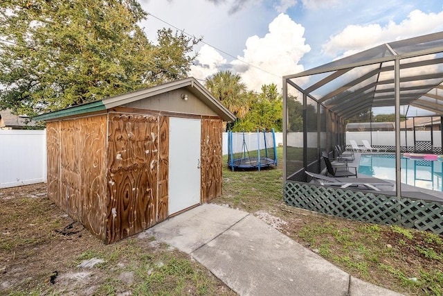 view of outbuilding with a trampoline and a fenced in pool