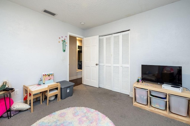 carpeted bedroom with a closet and a textured ceiling