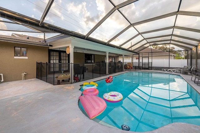 view of pool with glass enclosure and a patio area