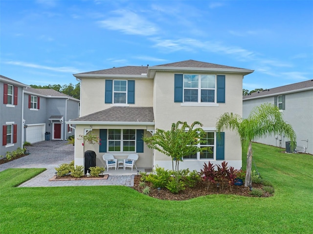 view of front of property featuring a garage, central AC unit, and a front yard