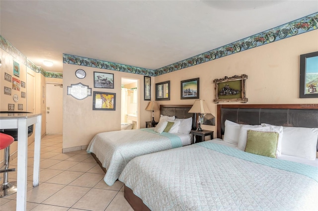 bedroom with ensuite bath and light tile patterned floors