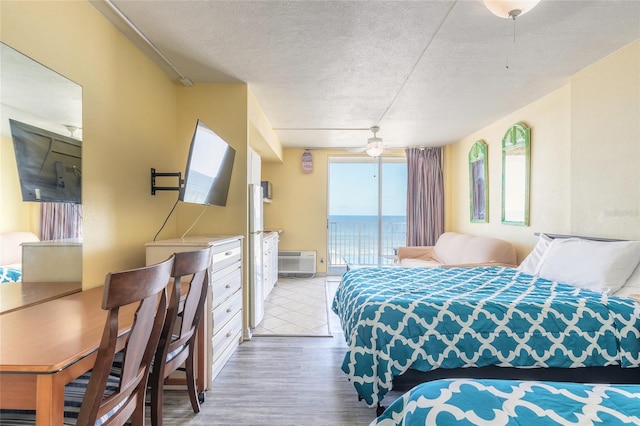 bedroom featuring a textured ceiling, access to outside, hardwood / wood-style floors, and ceiling fan