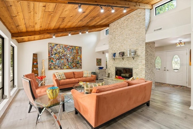 living room with beam ceiling, wooden ceiling, and light hardwood / wood-style flooring